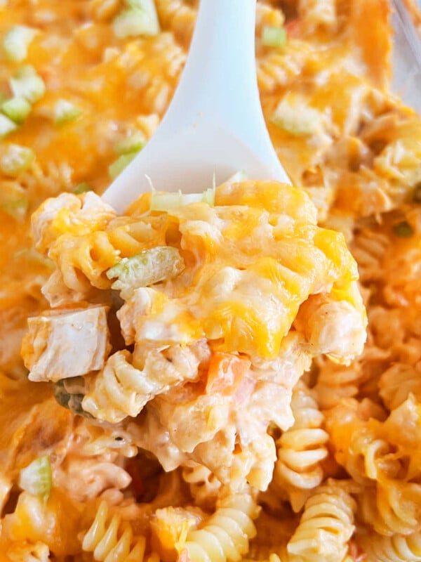 buffalo chicken casserole with pasta and vegetables on serving spoon.