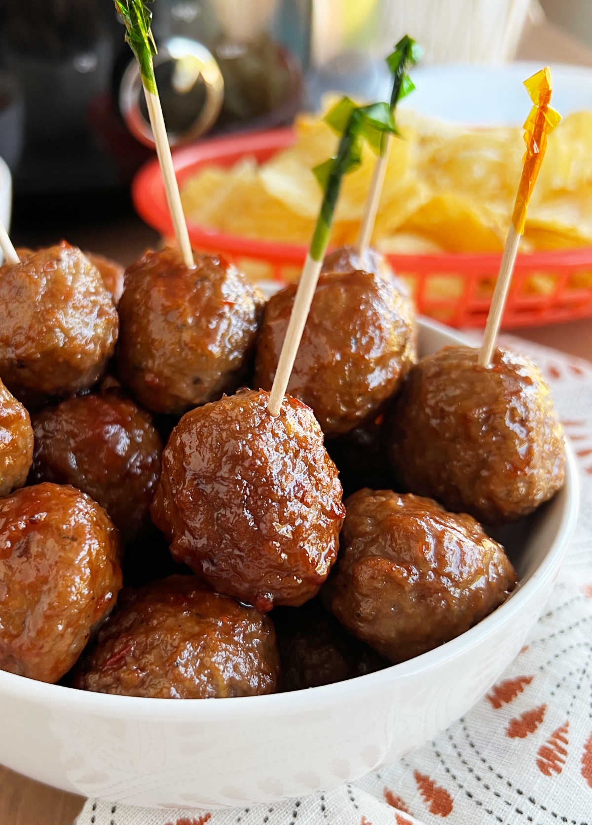 crock pot grape jelly meatballs in bowl with party toothpicks.