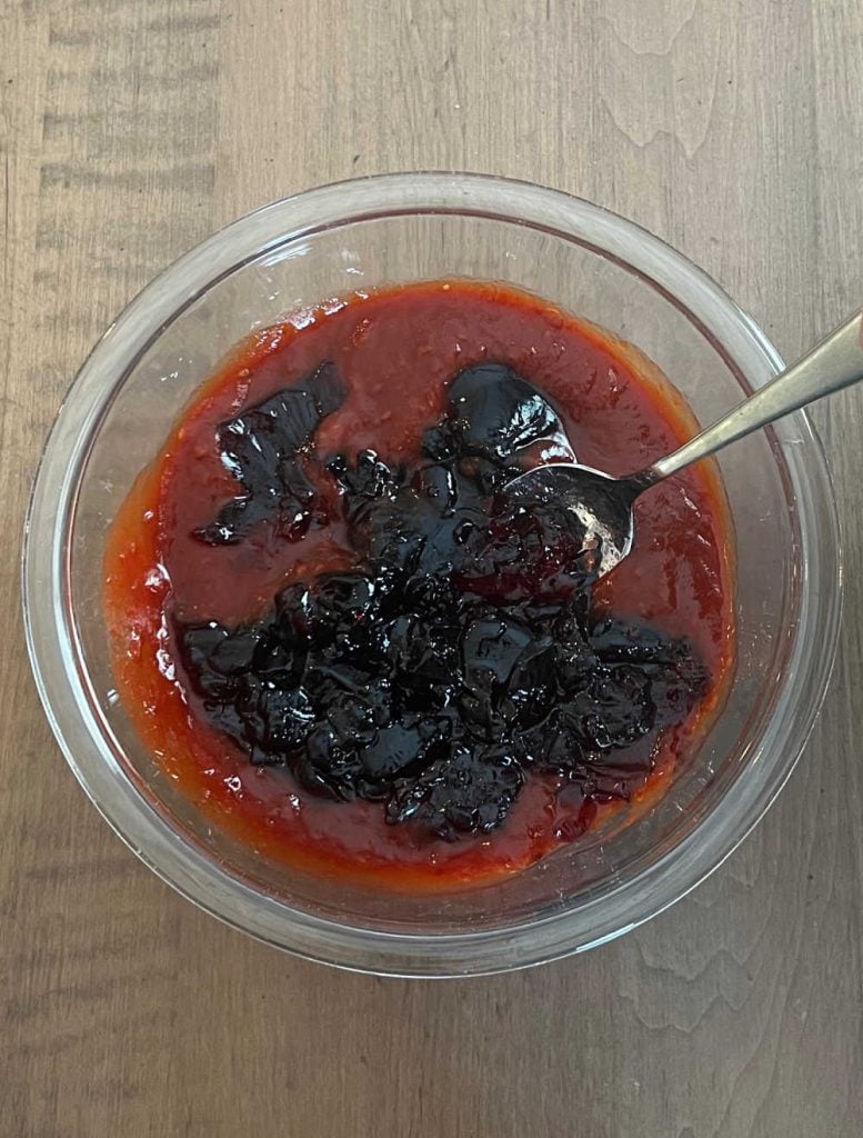 mix grape jelly with chili sauce in small bowl with spoon.