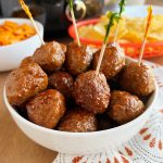 crockpot grape jelly meatballs with party toothpicks in serving bowl.