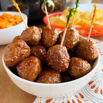 crockpot grape jelly meatballs with party toothpicks in serving bowl.