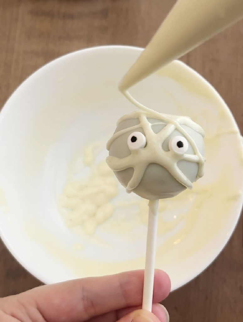 decorate mummy cake pop with candy melts.