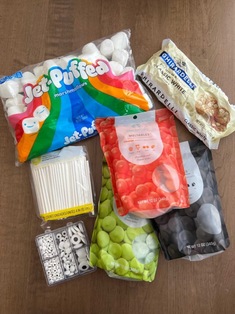 marshmallows, candy melts, white chocolate chips, candy eyes and lollipop sticks.