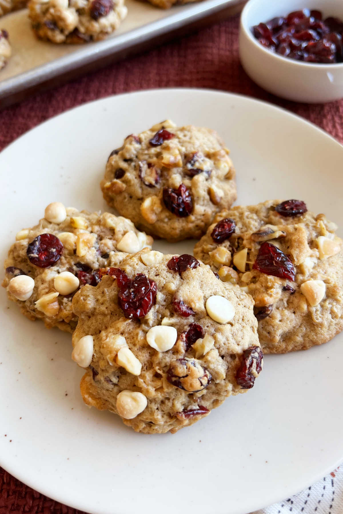 oatmeal cranberry cookies with walnuts, dried cranberries and white chocolate chips on plate.