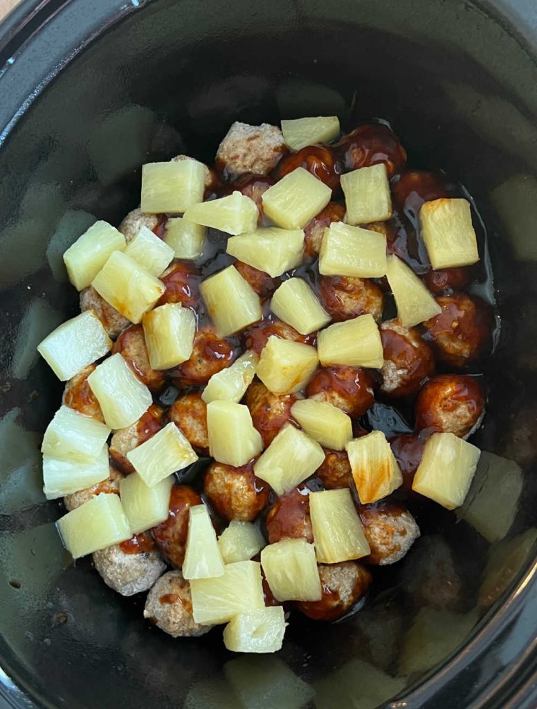 meatballs and pineapple chunks in slow cooker.