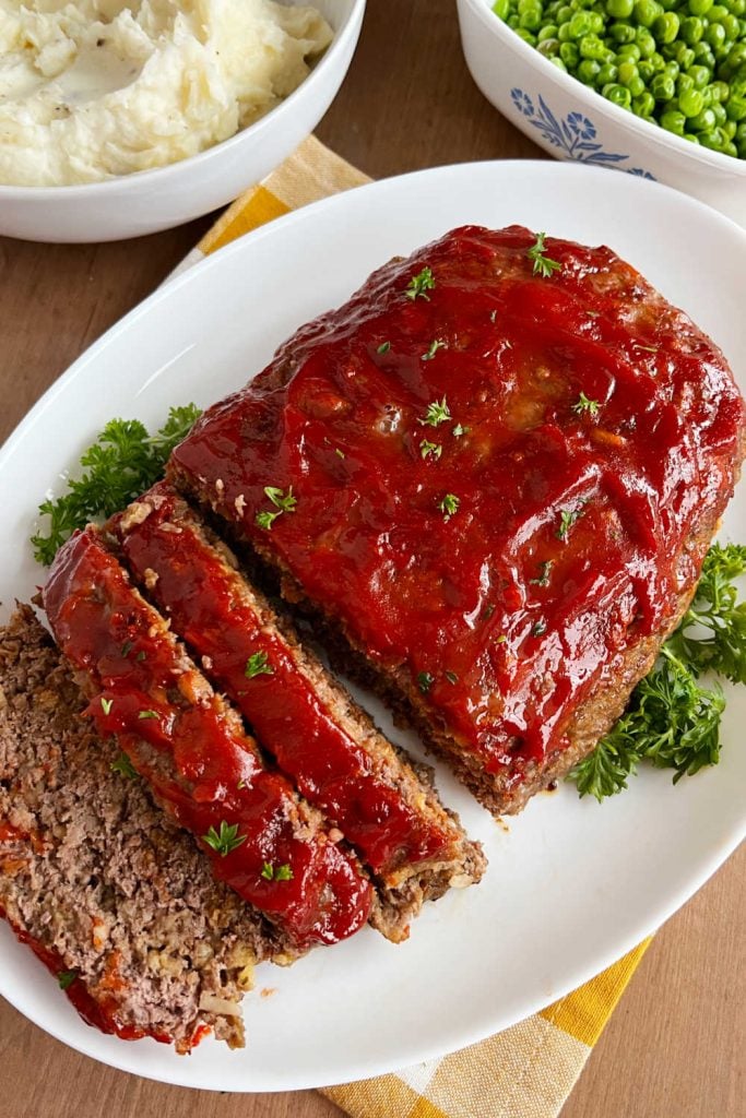 stove top stuffing meatloaf on platter with mashed potatoes and peas.