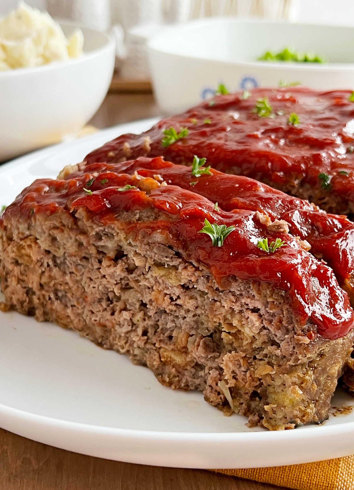 meatloaf with stove top stuffing and ketchup glaze sliced on a platter.