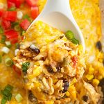 fiesta chicken casserole with rice and cheese on a serving spoon.