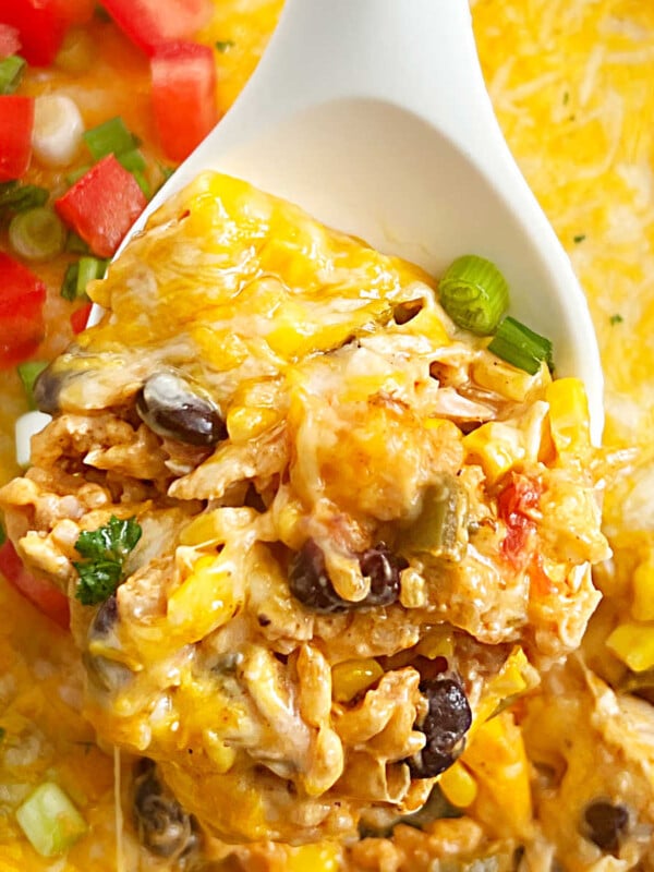 fiesta chicken casserole with rice and cheese on a serving spoon.
