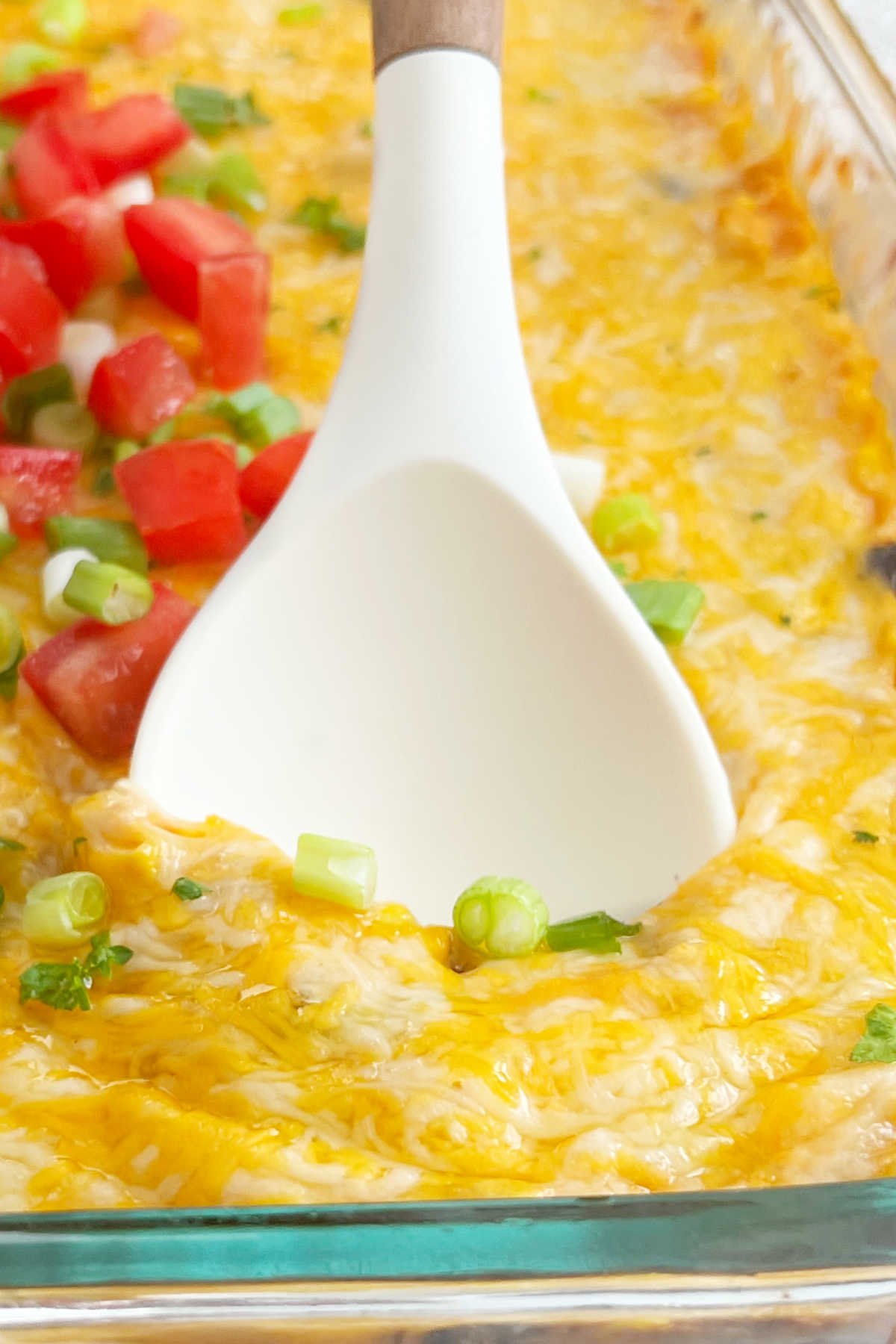 cheesy fiesta chicken casserole on serving spoon.