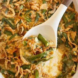 campbell's green bean casserole with fried onions on serving spoon.