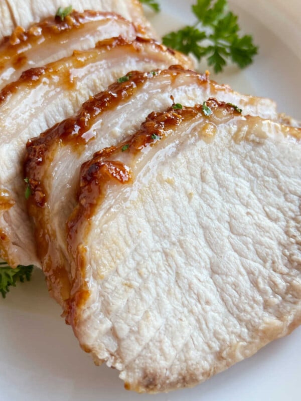 glazed maple mustard pork roast slices on a platter.