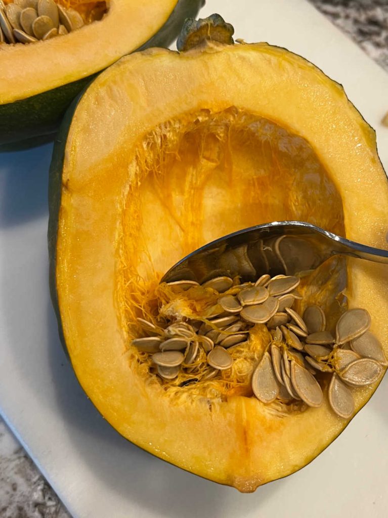scrape seeds out of acorn squash with spoon.