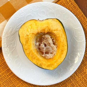 microwave acorn squash with butter and brown sugar on plate.