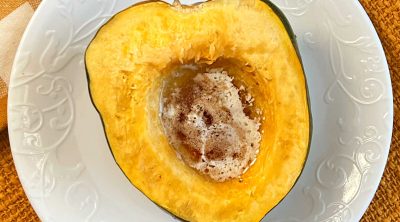 microwave acorn squash with butter and brown sugar on plate.