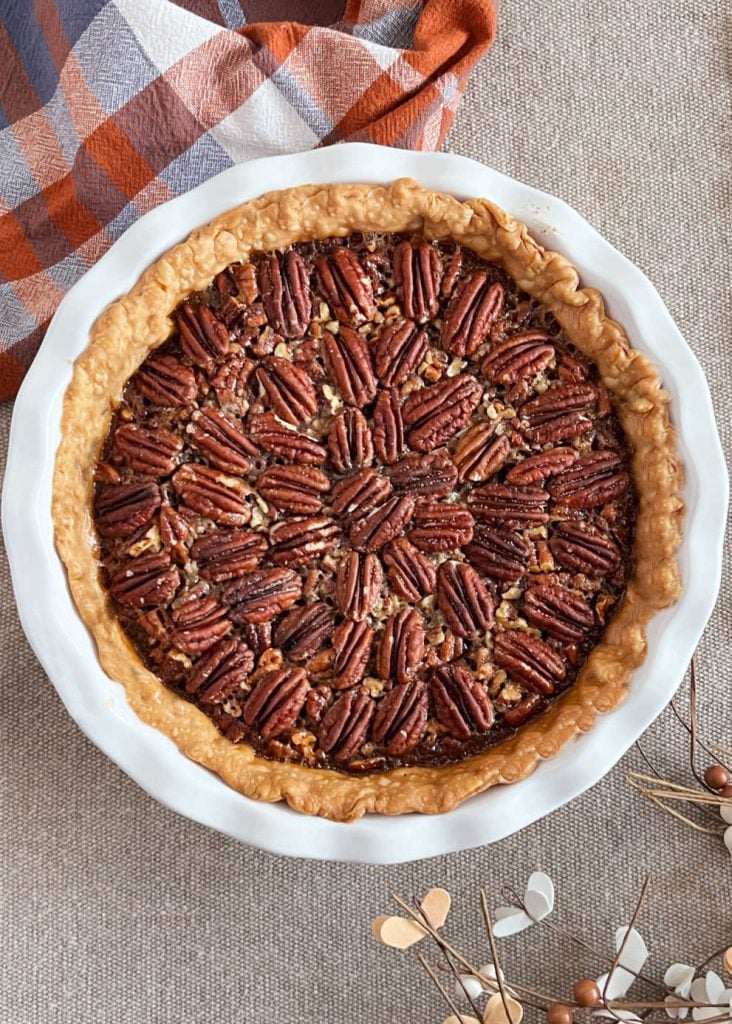 baked bourbon pecan pie in white pie dish.