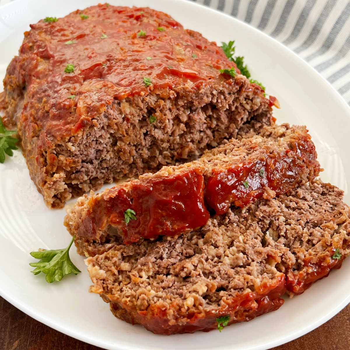 Quaker oats meatloaf with ketchup glaze sliced on a platter.