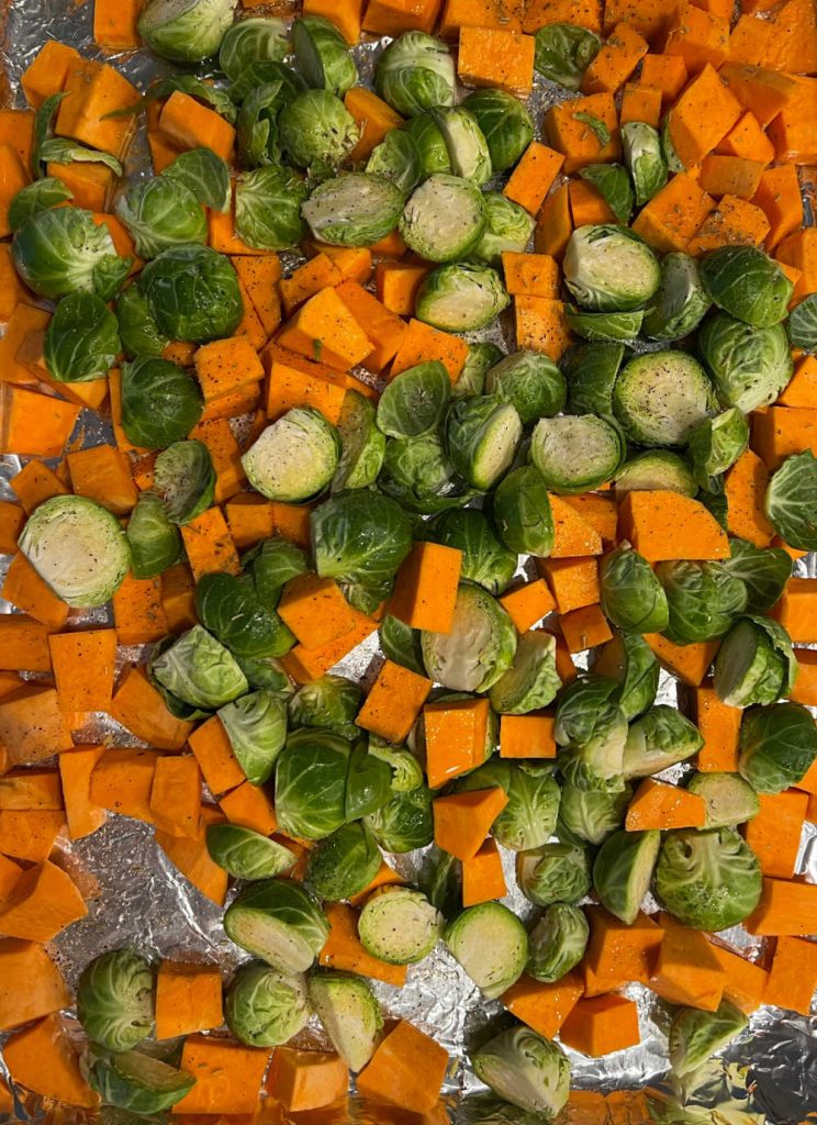 cut sweet potatoes and Brussel spouts on a sheet pan.