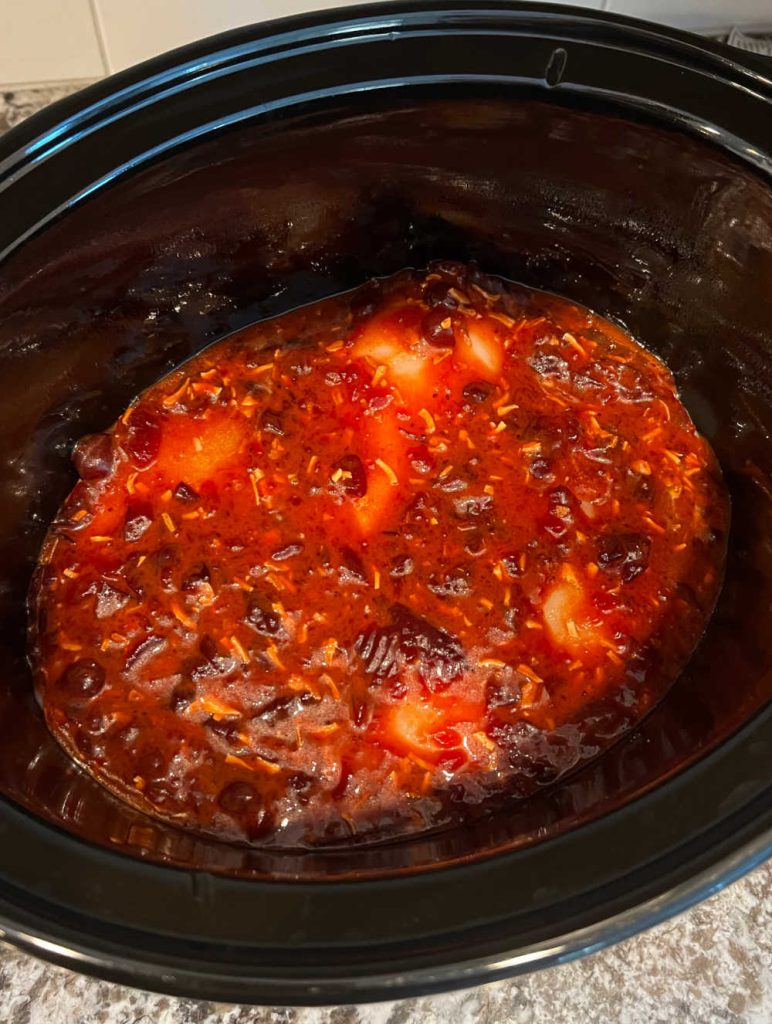 chicken breast covered in sauce mixture in crockpot.