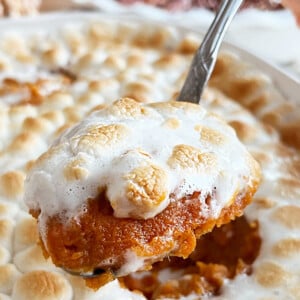 eggless sweet potato casserole with marshmallows on serving spoon.