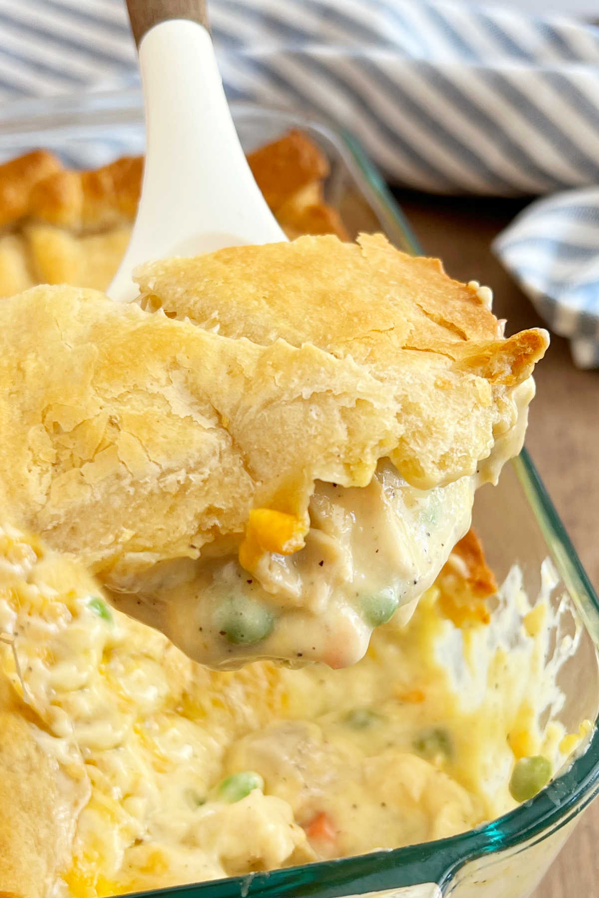 chicken pot pie with crescent rolls on a serving spoon.
