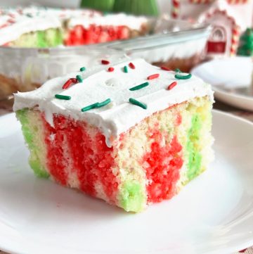 Christmas jello poke cake with cool whip frosting on plate.