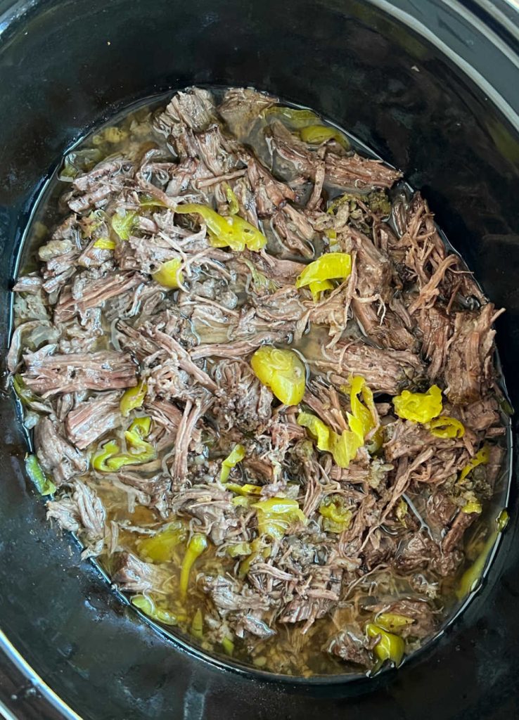 shredded italian beef with peppers in crockpot.