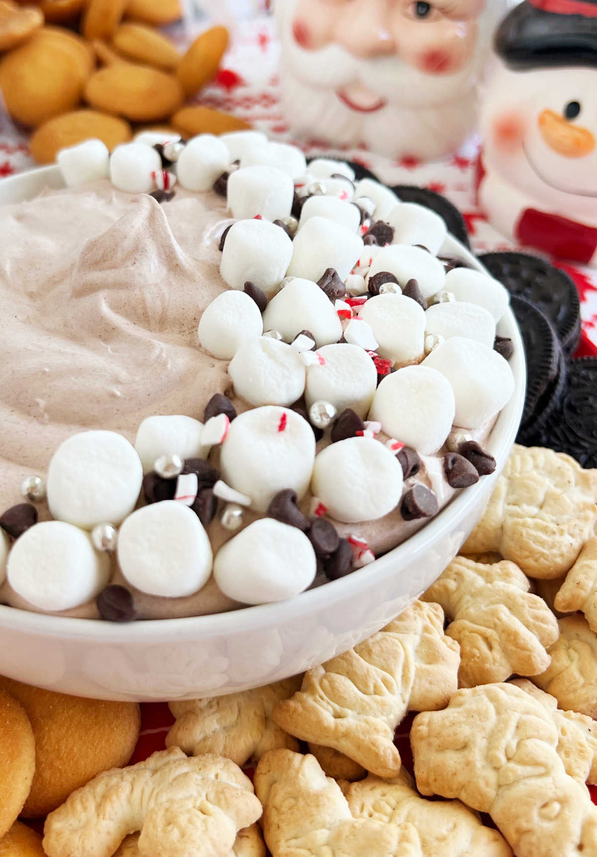 bowl of hot chocolate dip with marshmallows and animal crackers.