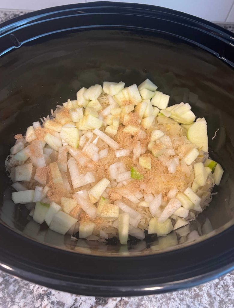 sauerkraut and apples with brown sugar in crock pot.