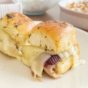 turkey sliders on Hawaiian rolls with cranberry sauce and cheese.