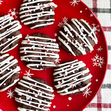 peppermint mocha cookies with white chocolate drizzle on plate.