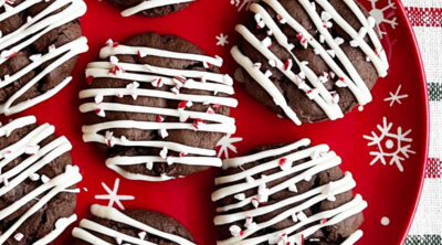 peppermint mocha cookies with white chocolate drizzle on plate.