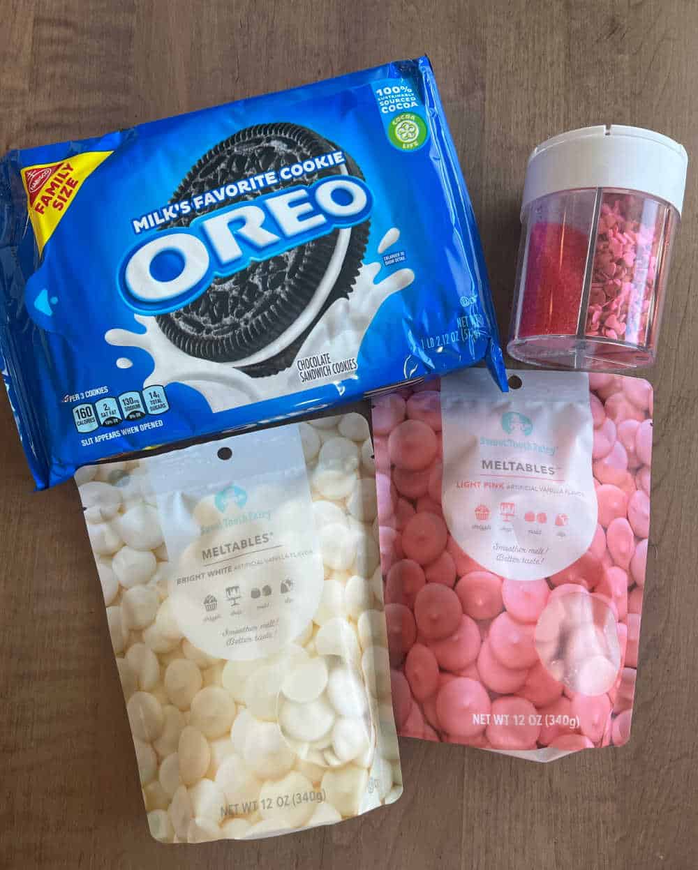 package of oreo cookies, white and pink candy melts and sprinkles.