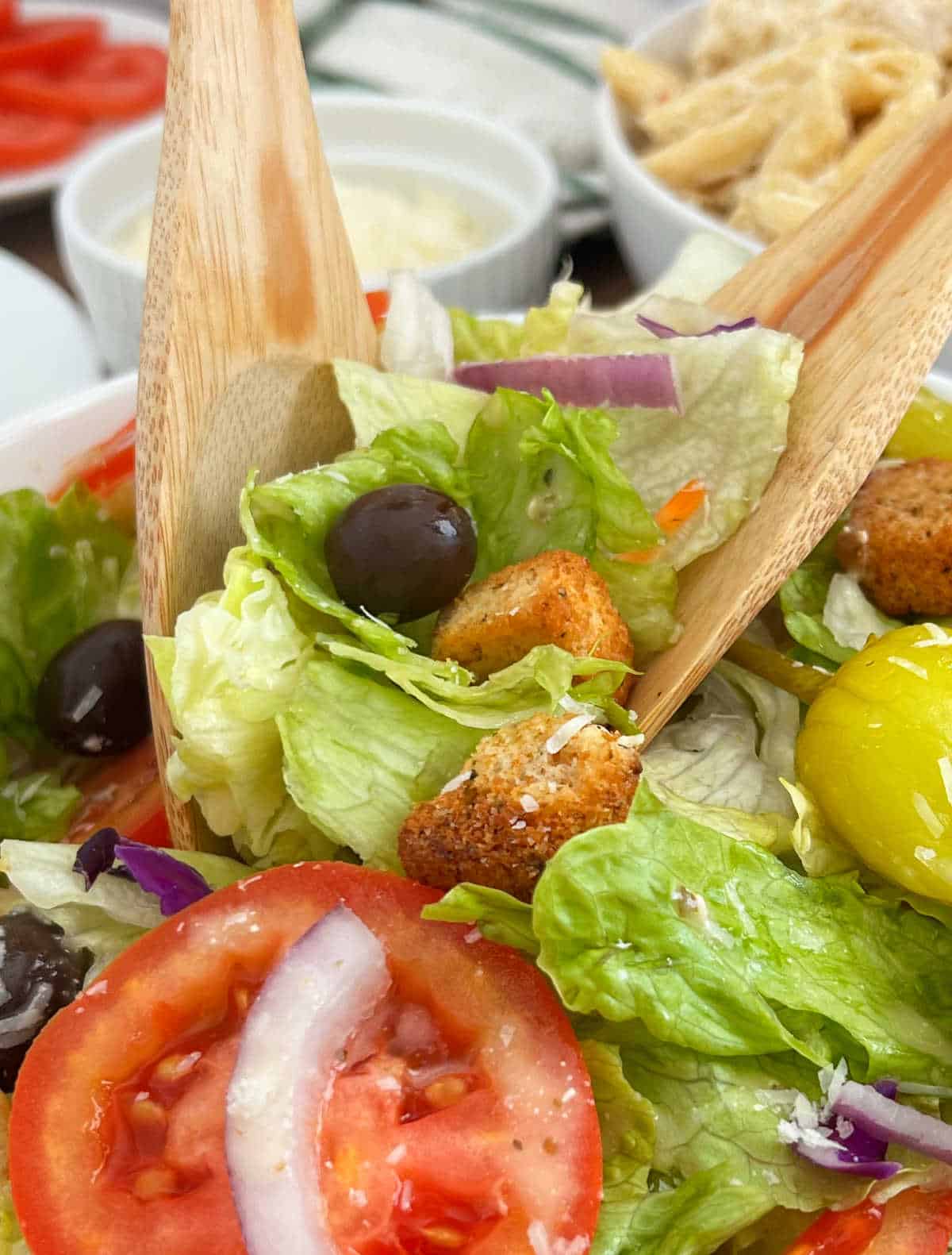 toss salad with wooden serving spoon and fork.