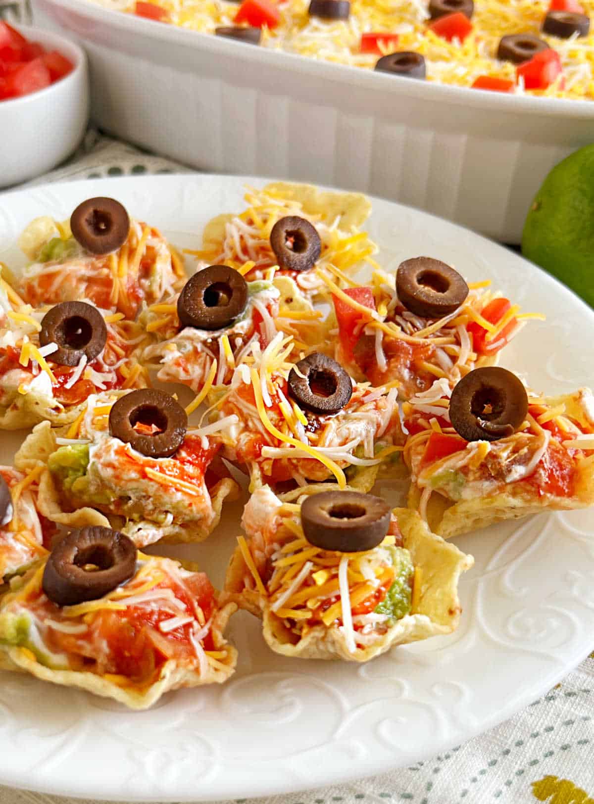 seven-layer dip bites served in individual tortilla chip Tostitos scoops.