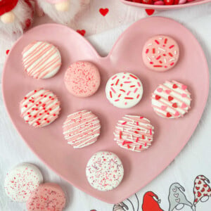 white chocolate dipped oreos covered with valentines day sprinkles.
