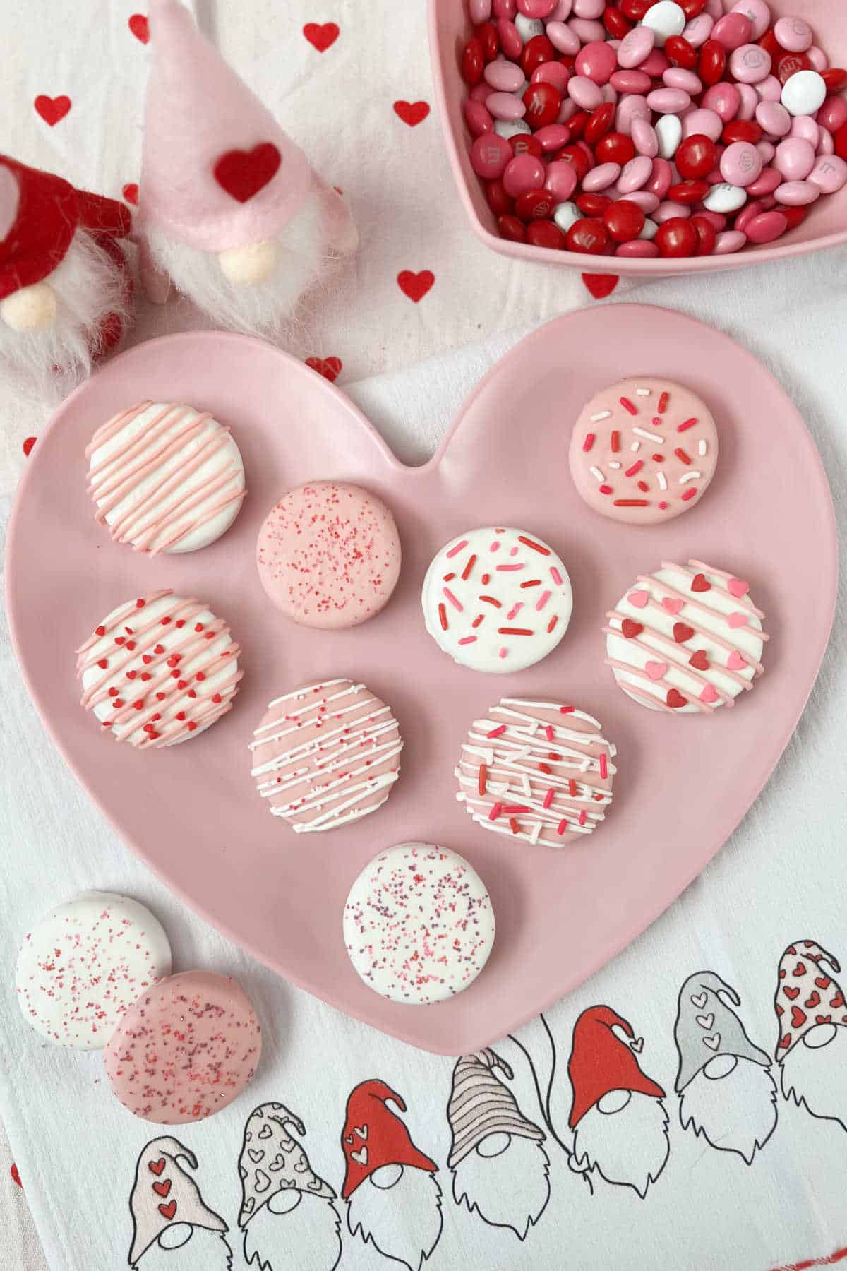 white chocolate covered oreos decorated for Valentines Day on heart plate.