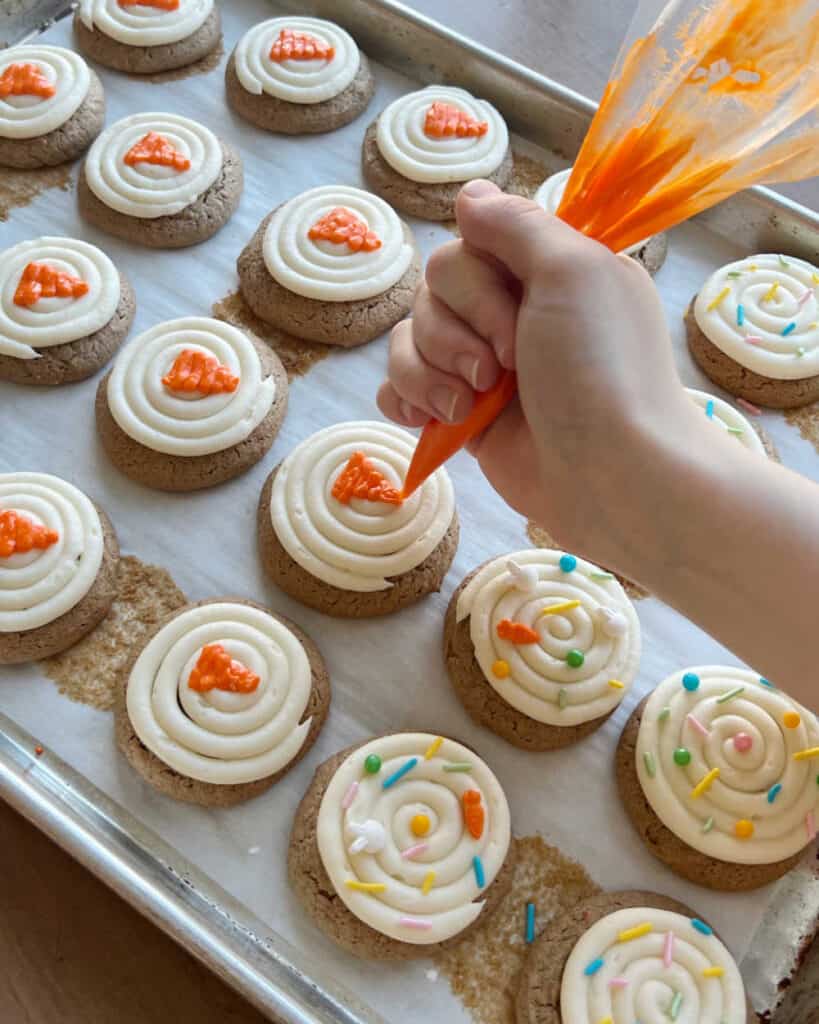 pipe orange carrots on frosted cookies.