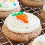 carrot cake mix cookies with cream cheese frosting and iced carrot on top.