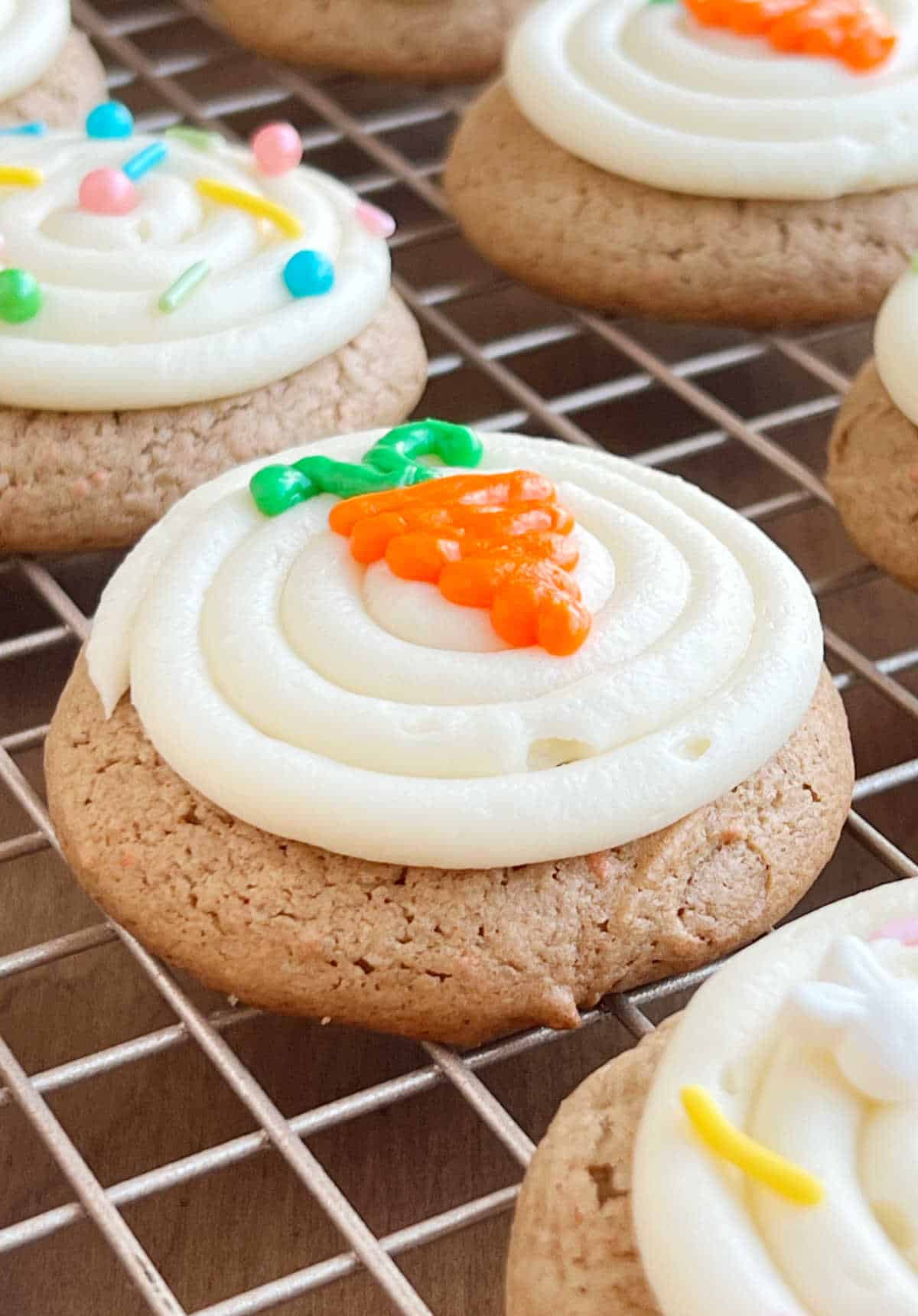 frosted carrot cake mix cookies on wire baking rack.