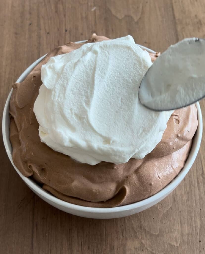 spread whipped topping over chocolate pie dip in bowl.