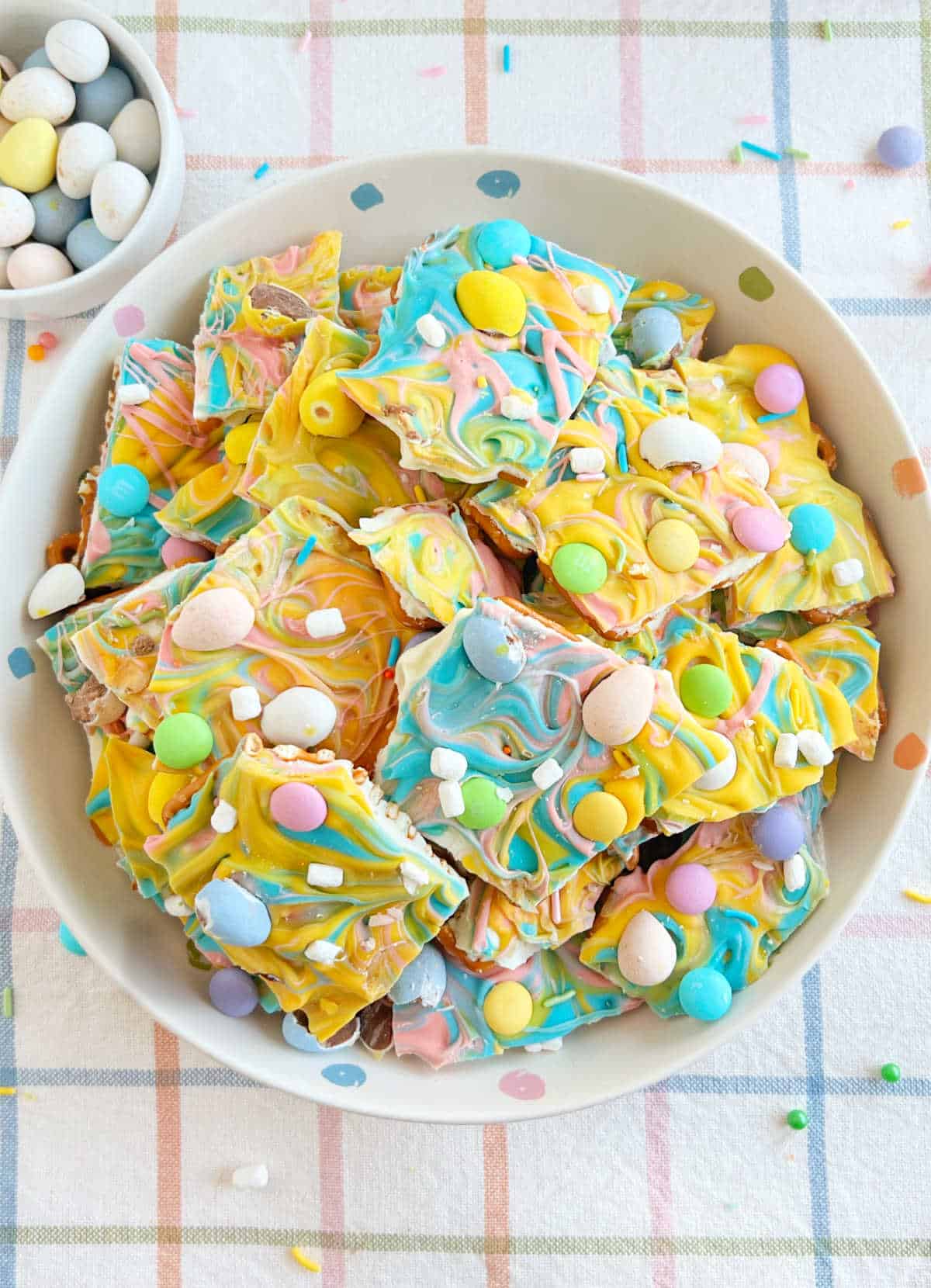 bowl of Easter bark with mini eggs, marshmallow bits, sprinkles and pretzels.