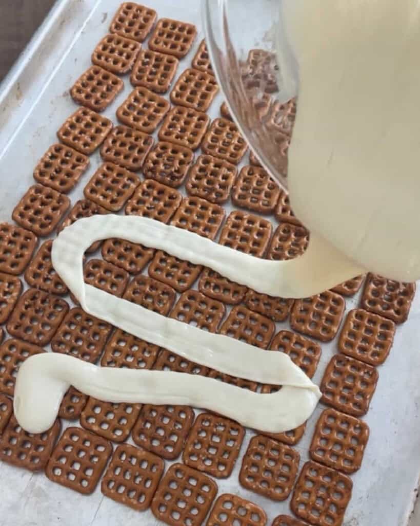 pour melted white chocolate over pretzels.