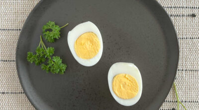 2 sliced hard boiled eggs on black plate.