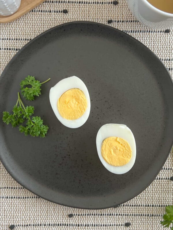 2 sliced hard boiled eggs on black plate.