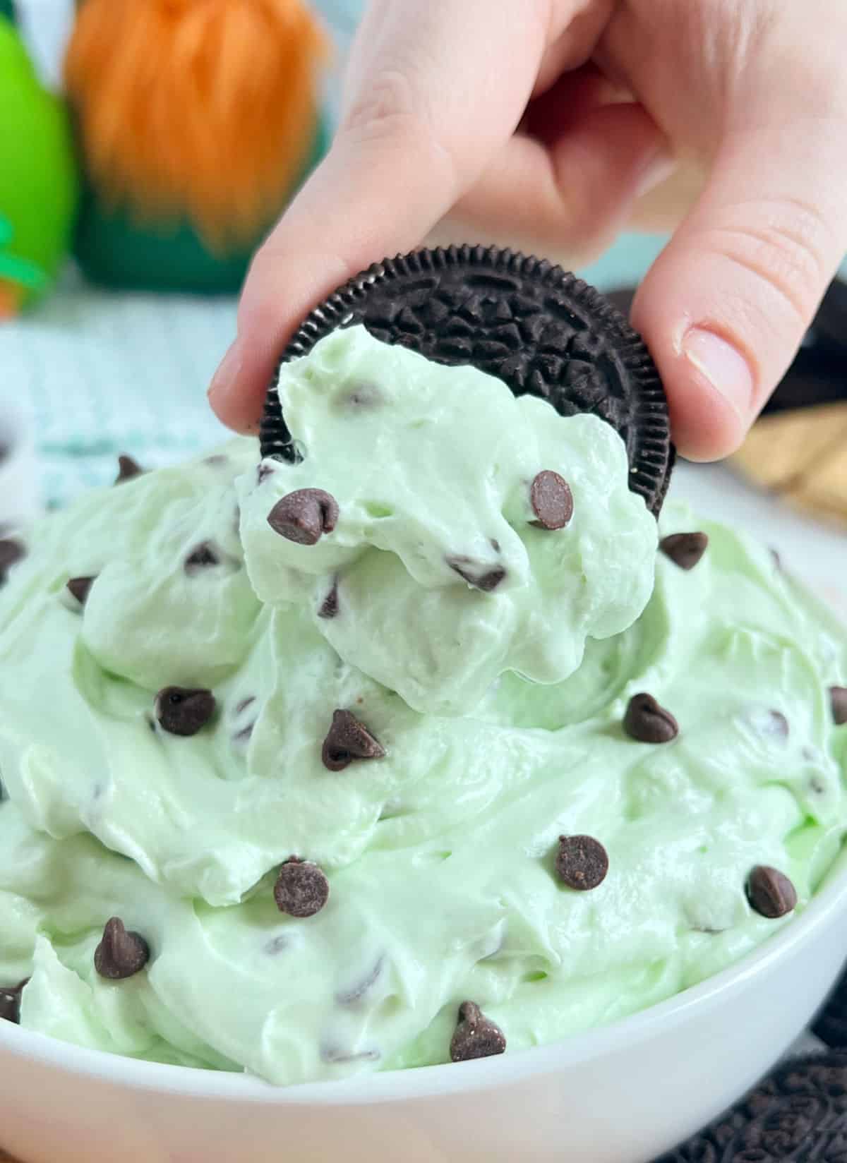 dip mint oreo cookie into mint chocolate chip dip.