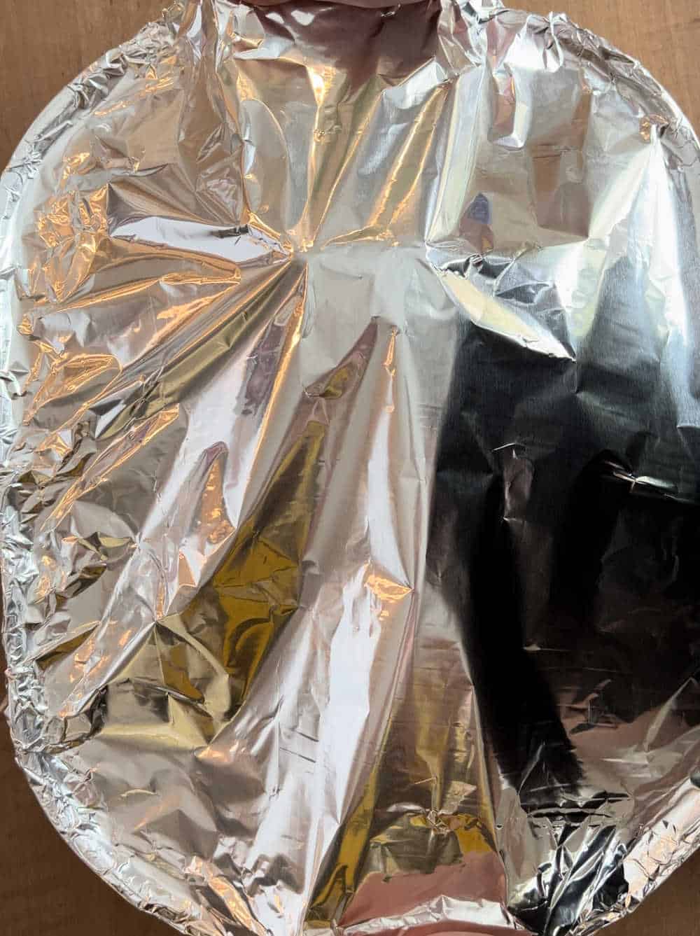 ham covered with aluminum foil in roasting pan.