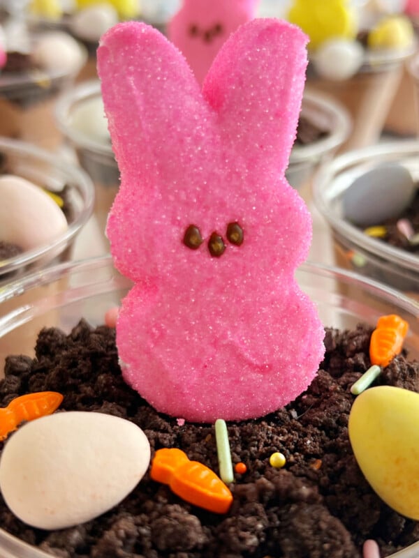 Easter dirt cups with bunny peeps, crushed Oreo cookies and candy eggs.