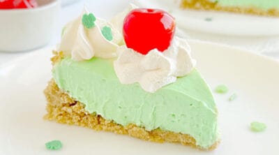 slice of shamrock pie with whipped cream and cherry on top.