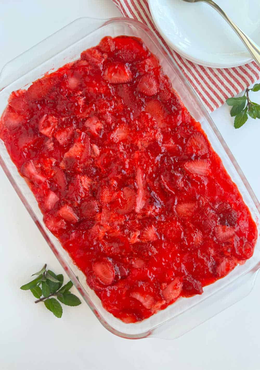 strawberry jello pretzel dessert in pan on the table.